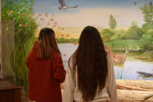 Students viewing the mural in the exhibition.